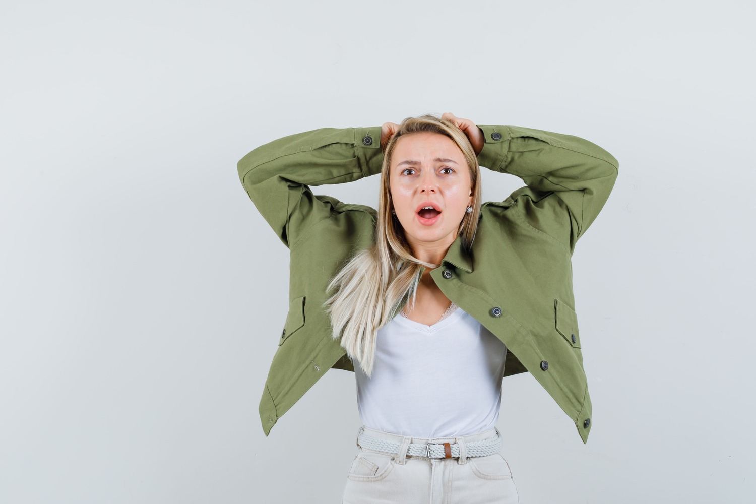 young-lady-clasping-head-with-hands-jacket-singlet-looking-mournful-front-view